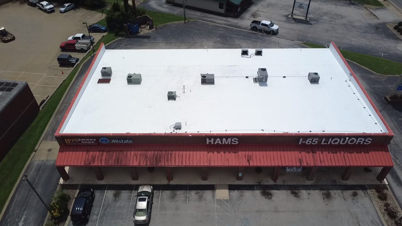 Aerial view of the completed white membrane roof over the I-65 Liquors and HAMS retail center